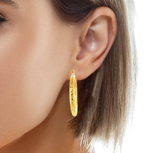 Close-up of a woman's ear showcasing the Beautiful Texturized Hoops Earrings, which are 4cm round and made from 14k gold-filled material, guaranteeing a lead and nickel free experience.